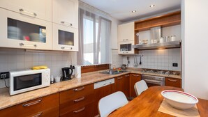 A modern kitchen with white cabinets, a microwave, a coffee maker, and a stove. - Venice Rio dei Greci San Marco (Venice)