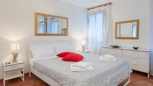 A neatly arranged bedroom with a bed, two bedside tables, a dresser, and two large mirrors. - Venice Rio dei Greci San Marco (Venice)