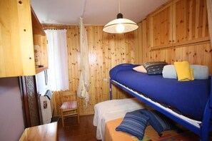 A bunk bed room with wooden walls, a small table, and a chair. - La Casa di Villalago (Villalago)