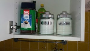 A kitchen shelf with a coffee maker, a bottle of oil, and two containers labeled 'SALE' and 'ZUCCHERO'. - Nice Apartment Venice (Mestre)