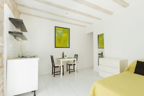 Cozy retreat with a bed, dining area, and kitchenette.