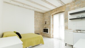 A modern bedroom with a bed, a TV, and a kitchenette. - Eco B&B Old Town Beach (Split)