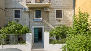 A two-story building with a balcony, a sign indicating it is a doctor's office, and a green door. - Eco B&B Old Town Beach (Split)