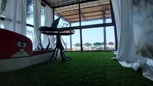 Una habitación con un ventanal grande, un sofá rojo y una pequeña mesa.