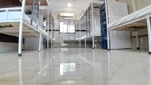 Una habitación de hotel con literas, un armario blanco y un ventanal grande.