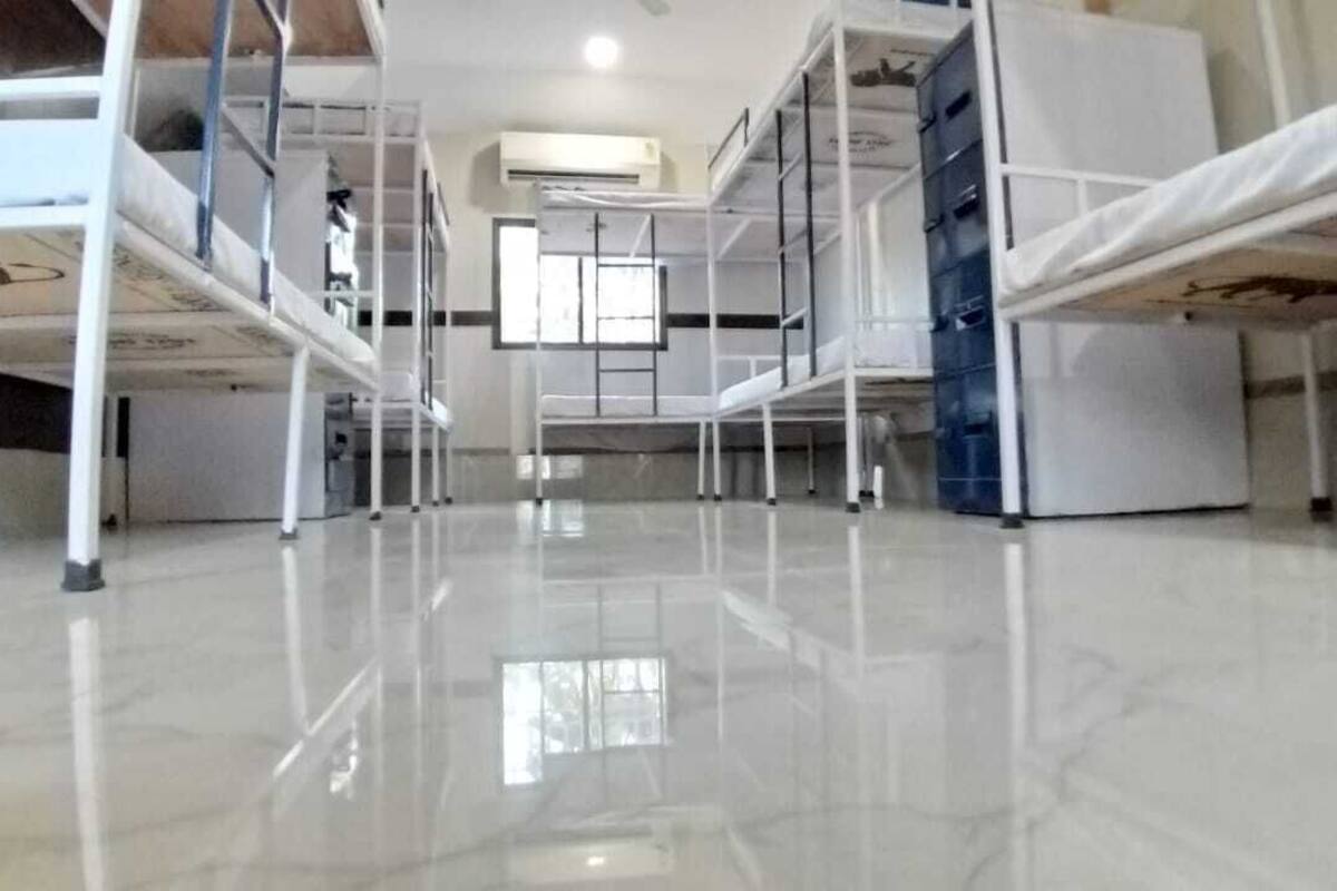 Una habitación de hotel con literas, un armario blanco y un ventanal grande.