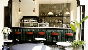 A bar area with a counter, stools, and hanging lights. - De An Hotel (Da Nang)
