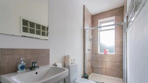 A bathroom with a sink, toilet, and glass shower enclosure. - 70 Elm Street (Cardiff)