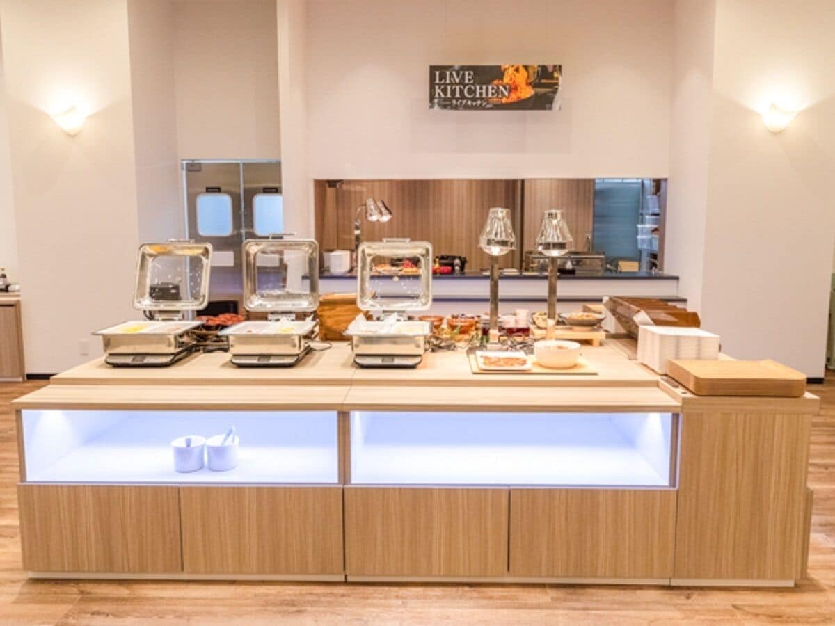 Un bufé con diferentes opciones de comida y utensilios de servicio.