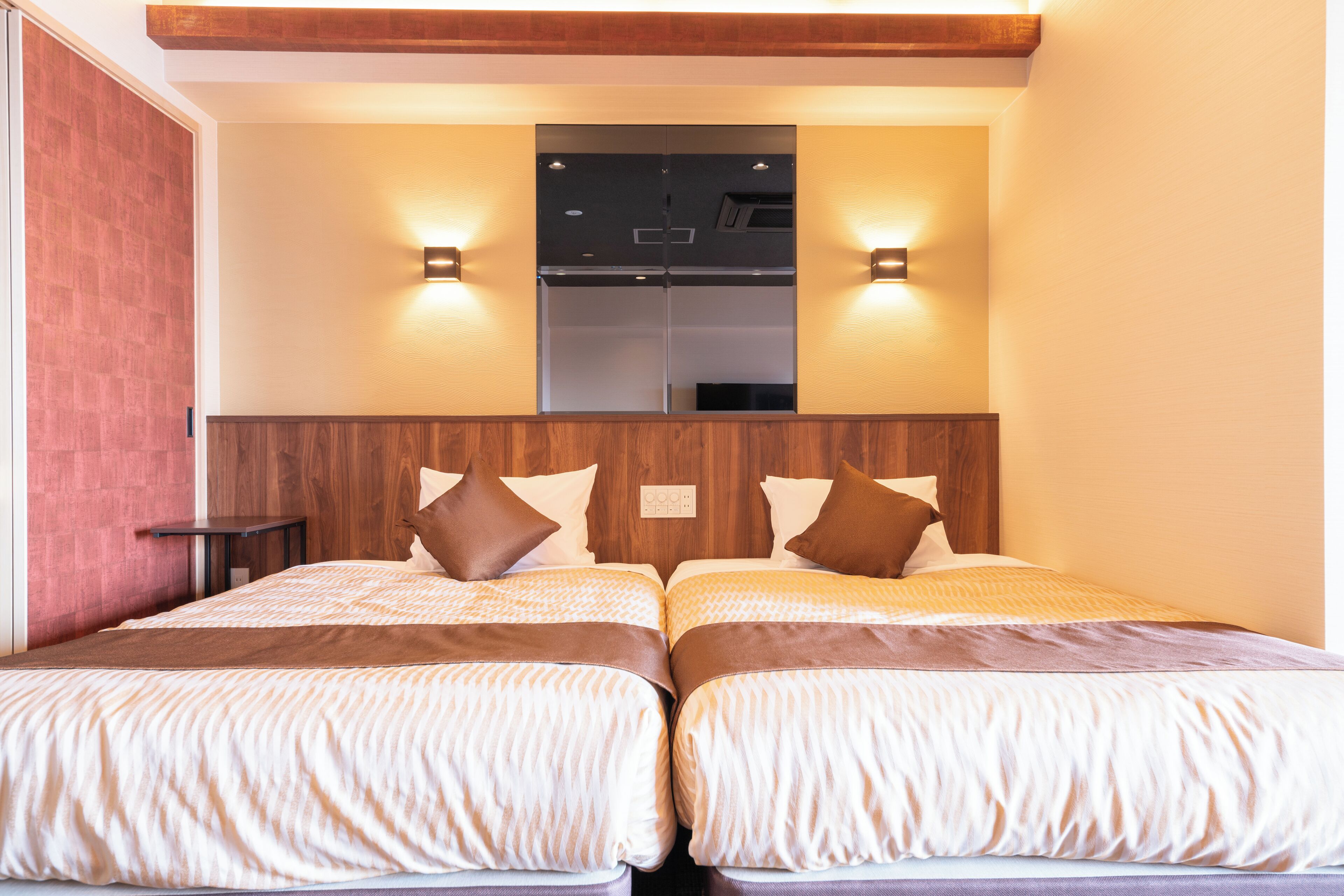 A double bed with a wooden headboard, two bedside tables, and wall-mounted lights.