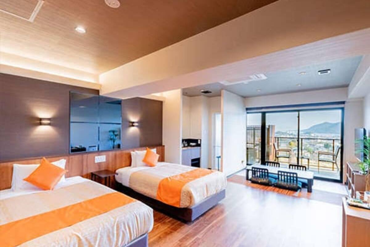 A modern hotel room with two beds, a balcony with a view, and a large mirror.