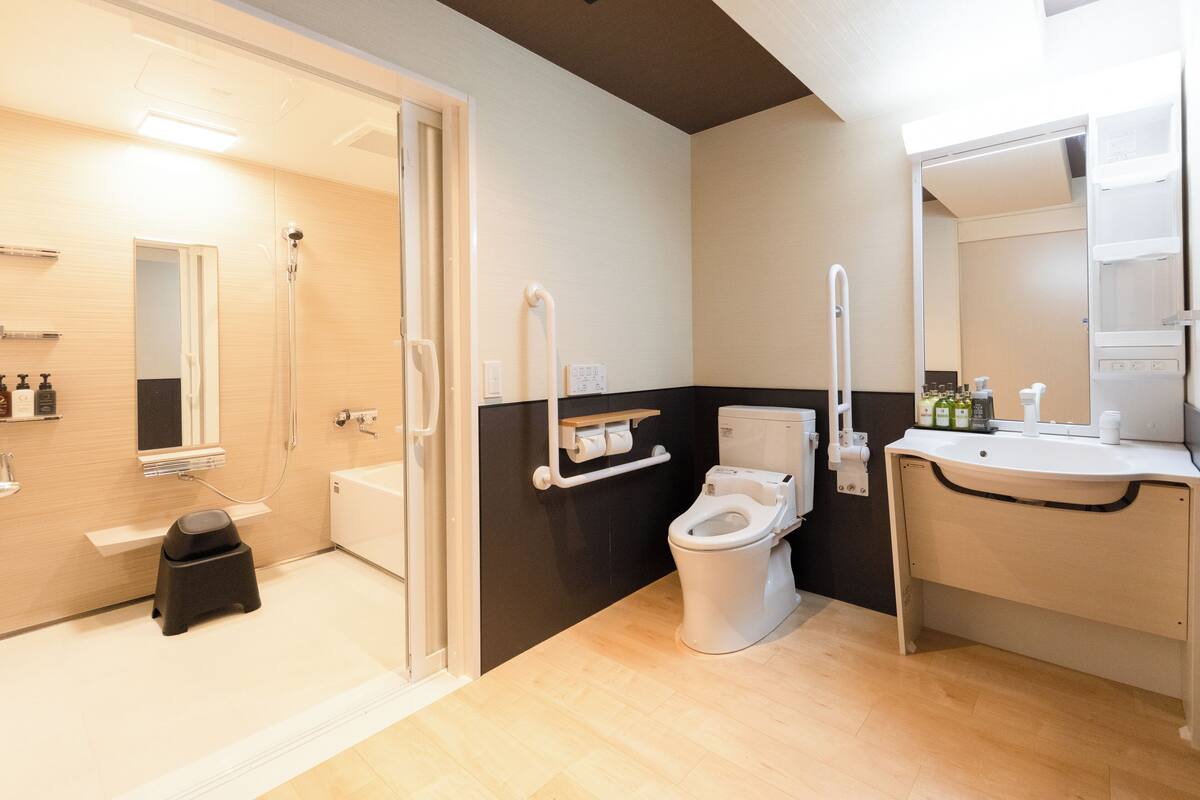 A modern bathroom with a shower, toilet, and sink.