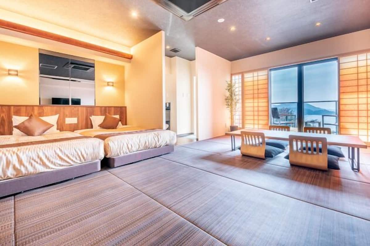 Une chambre d’hôtel moderne dotée d’un grand lit, d’un coin salon avec une table et d’une vue sur l’extérieur.