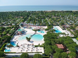 An aerial view of a resort with multiple swimming pools, a water park, and a beach area. - Victoria Mobilehome Camping Union Lido Vacanze (Cavallino-Treporti)