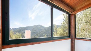 A room with a large window offering a view of a mountain and trees. - 4 bedroom beautiful home in Ciminà (Ciminà)