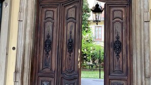 Une grande et somptueuse porte en bois, ornée de sculptures complexes, encadrée par un arc en pierre.