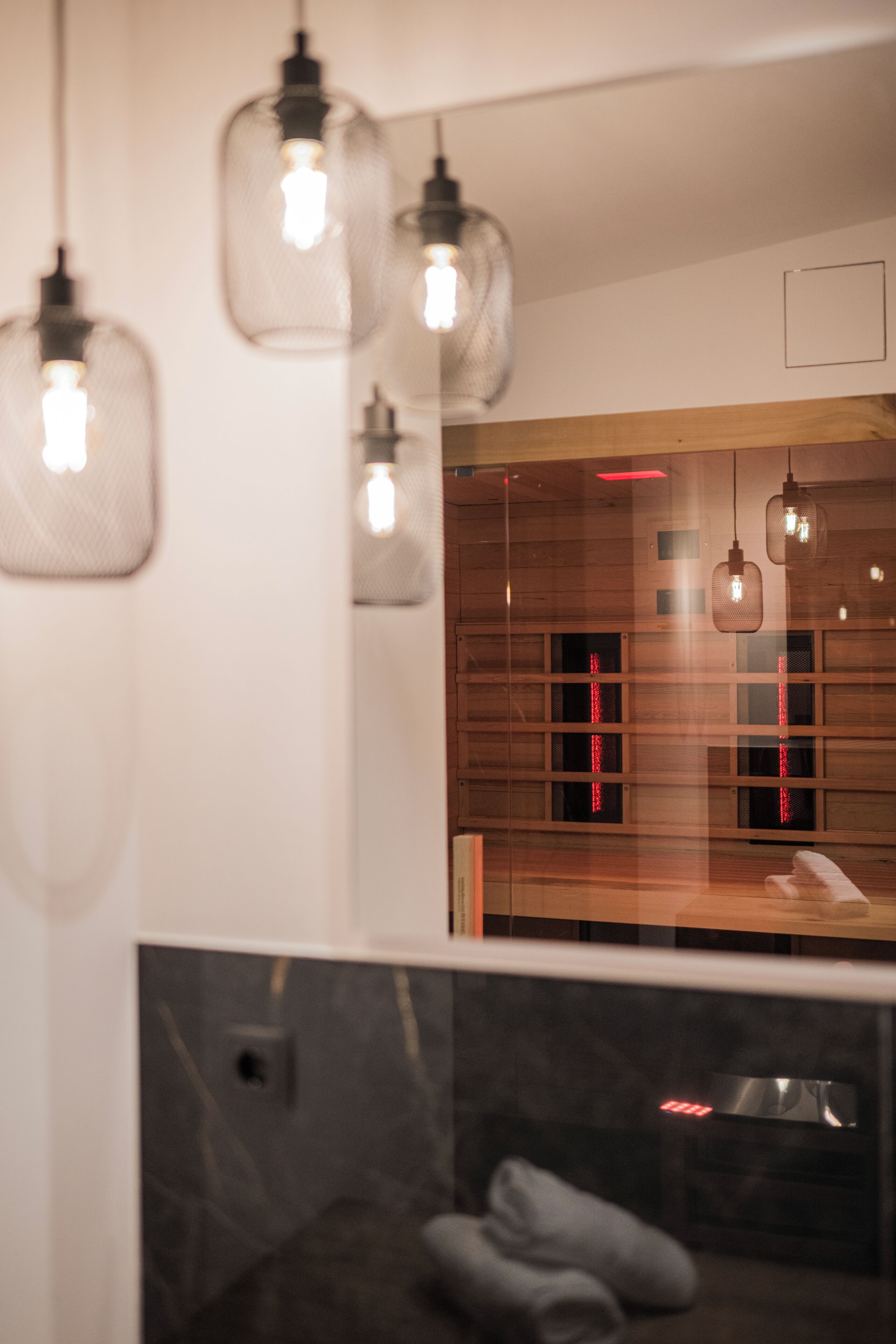 A modern bathroom with a wooden vanity, a mirror, and a shower area.