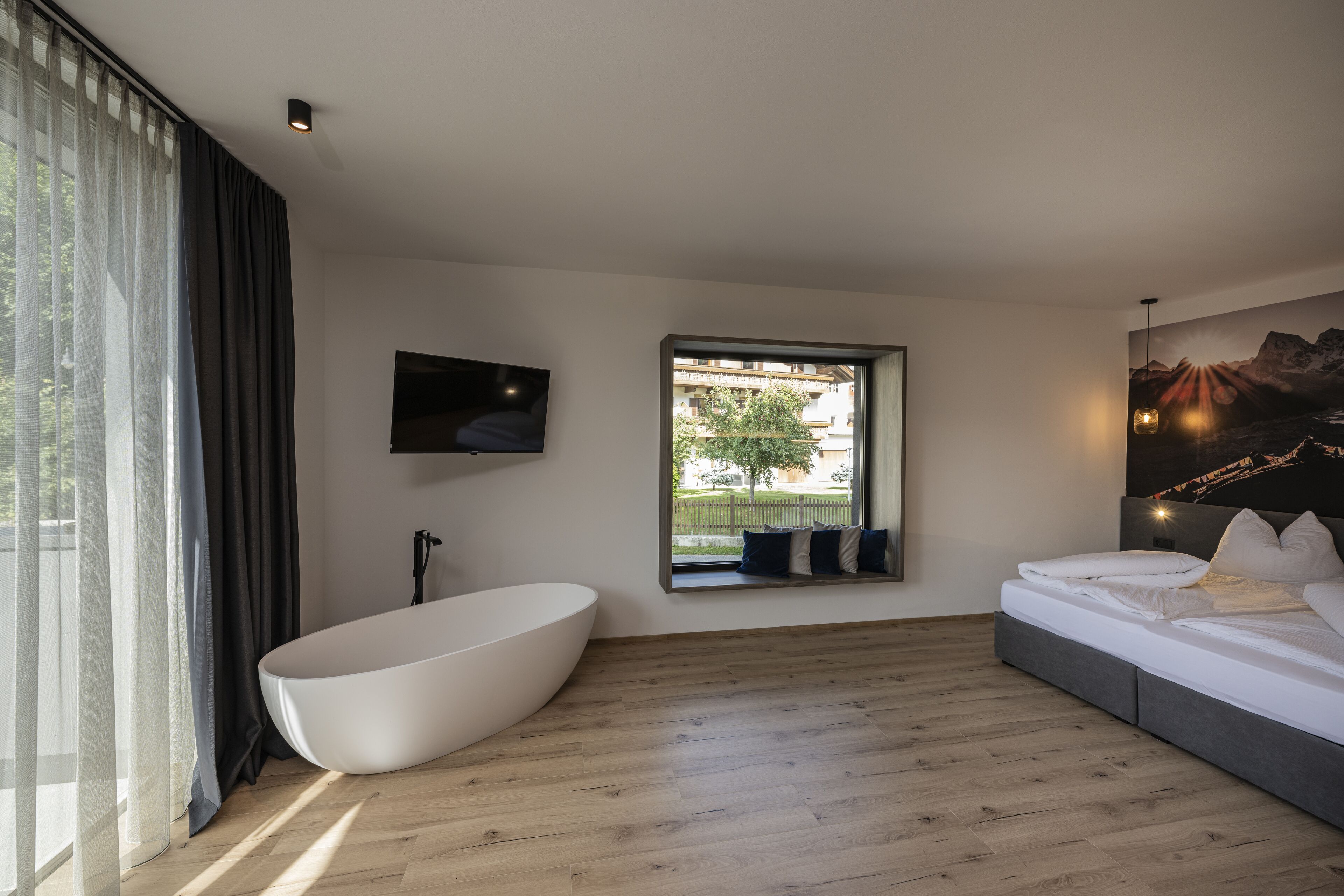 Une chambre à coucher moderne avec une grande fenêtre, une baignoire et un lit.
