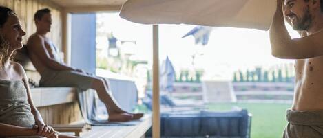A wooden deck with a bench, a lounge chair, and a massage table.