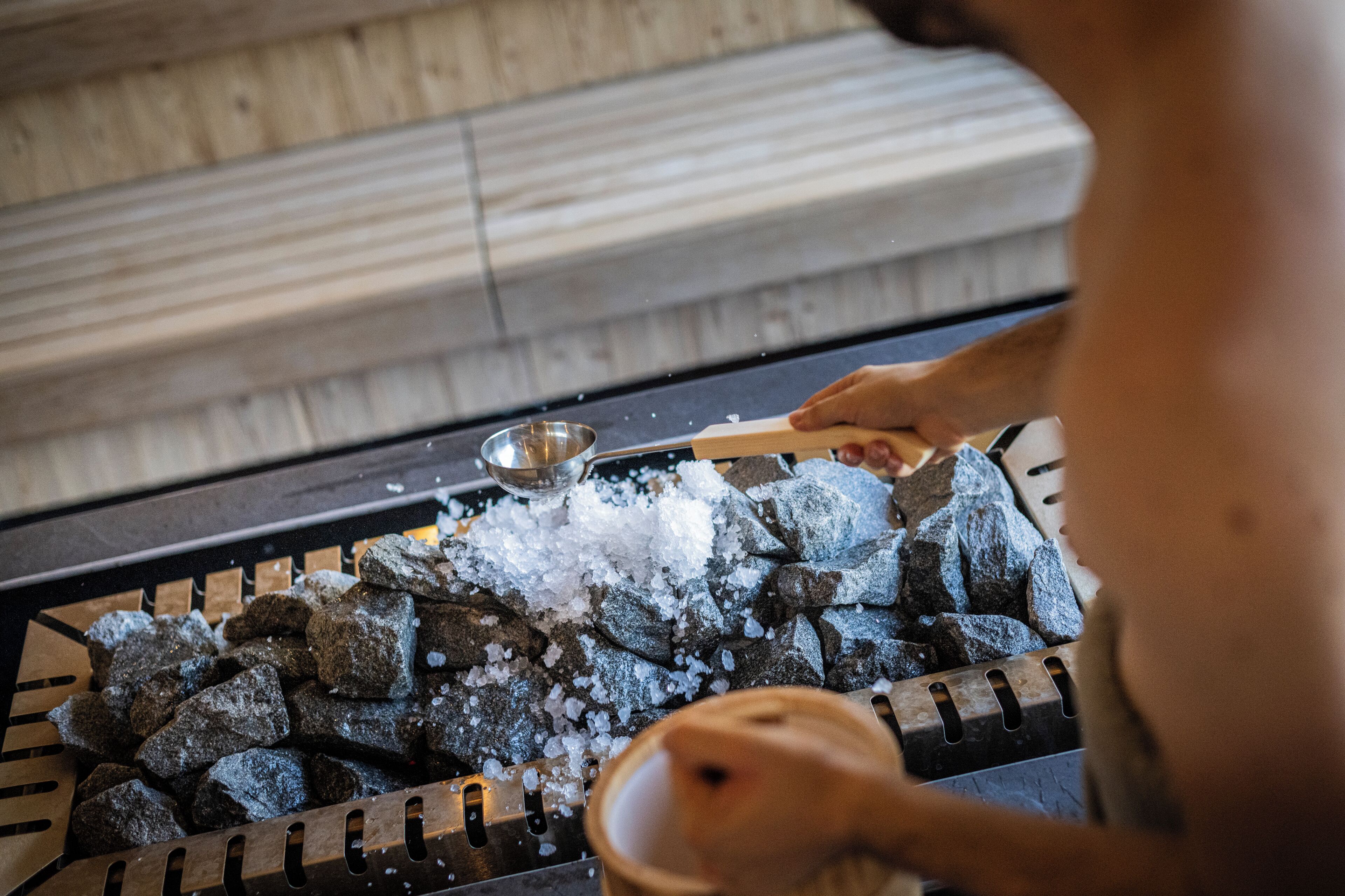 A person handling charcoal and ice in a grill setup.