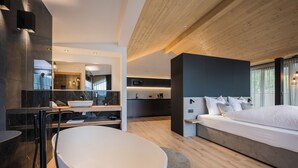 Quarto moderno com cama grande, escrivaninha embutida e banheiro separado com banheira.