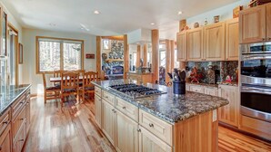 A spacious kitchen with wooden cabinets, granite countertops, and stainless steel appliances. - Boulder Lodge At Peak 8 4 Bedroom Home by RedAwning (Breckenridge)