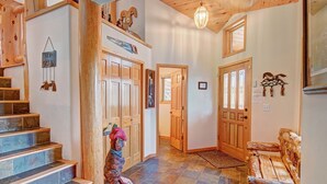 A wooden staircase leading to a door, a bench, and a wall with a hanging sign. - Boulder Lodge At Peak 8 4 Bedroom Home by RedAwning (Breckenridge)