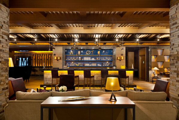A modern bar area with wooden beams, a bar counter, and seating. - Magna Pivot Hotels - Boutique Class (Kayseri)