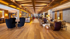 A spacious lobby with wooden flooring, modern furniture, and a bar area. - Magna Pivot Hotel - Boutique Class (Kayseri)