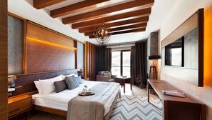 A modern hotel room with a large bed, wooden headboard, a desk, and a large window offering a view. - Magna Pivot Hotel - Boutique Class (Kayseri)