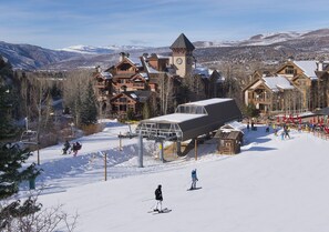 A ski resort with wooden buildings, a ski lift, and a snowy mountain backdrop. - Aspenwood 102 2 Bedroom Condo by RedAwning (Edwards)