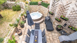 Eine Terrassenanlage mit Whirlpool, Sitzgelegenheiten und Blumentöpfen.