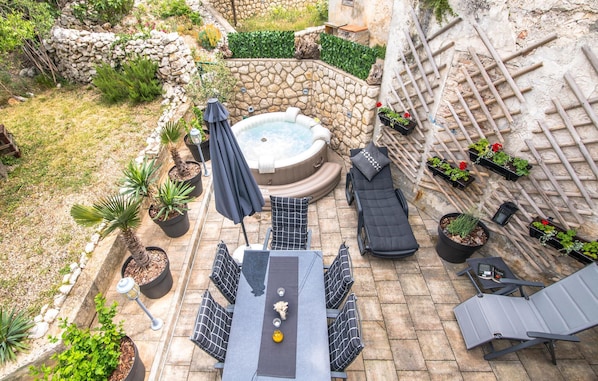 A patio area with a hot tub, seating, and potted plants. - 3 bedroom luxurious home in Miholascica (Miholascica)