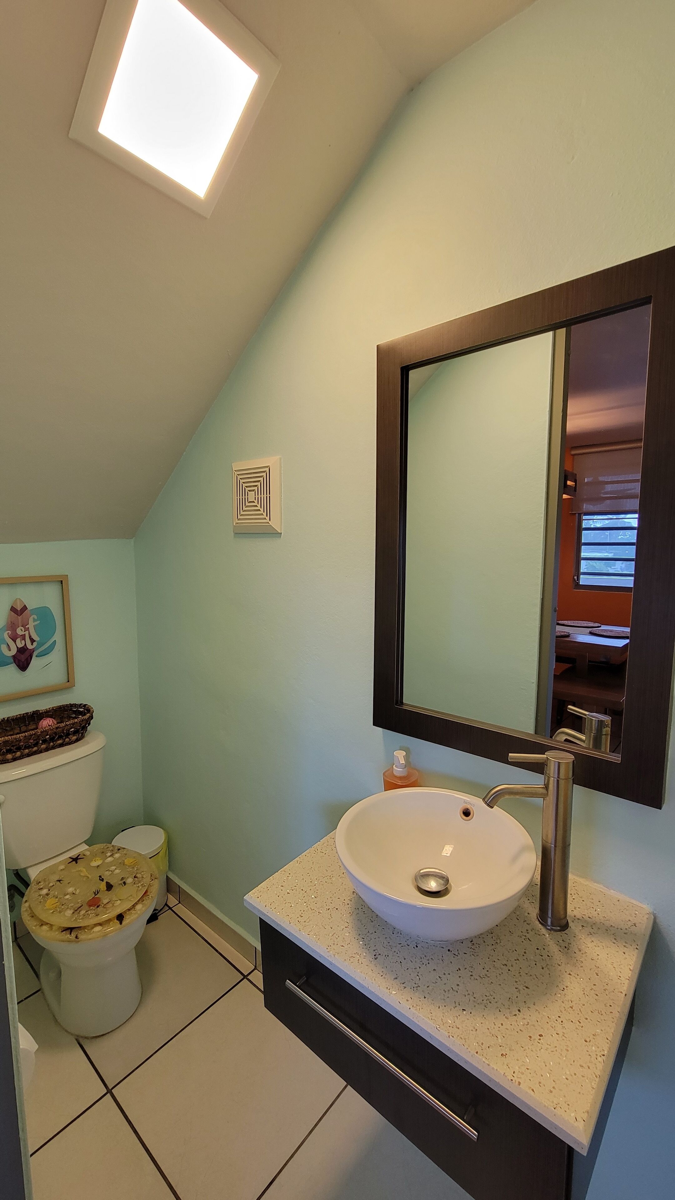 A bathroom with a white sink, a mirror, and a toilet.