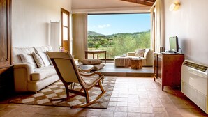 A cozy living room with a rocking chair, a sofa, and a TV stand. - Finca Sos Ferres D'en Morey (Manacor)
