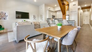 Una cocina moderna con armarios blancos, una mesa de comedor de madera y un microondas integrado.