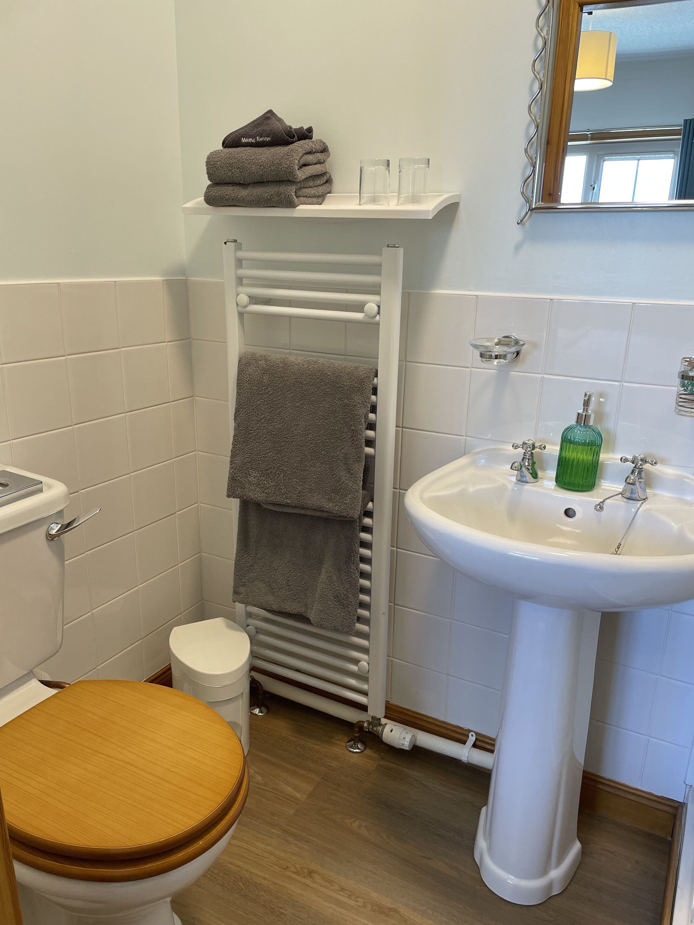 A bathroom with a toilet, sink, and towel rack.
