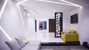 A modern living room with a grey sofa, a yellow sofa, and a black partition. - Elite Pyramids Boutique Hotel (Giza)