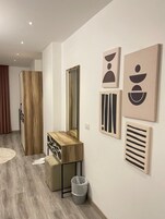 A modern bathroom with a wooden vanity, a large mirror, and minimalist wall art.
