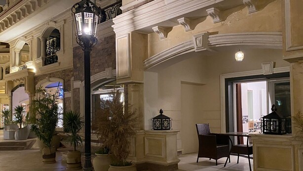 A grand entrance with a staircase leading to a covered area, featuring ornate columns and a large potted plant. - Elite Pyramids Boutique Hotel (Giza)