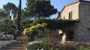 A stone staircase leading to a stone building with a garden and trees in the background. - Charming villa pool near sea to couple with stay in Italy (Itri)