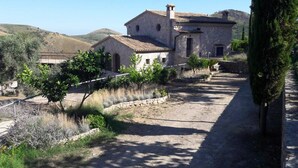 A stone building with a tiled roof, surrounded by a gravel path and greenery. - Charming villa pool near sea to couple with stay in Italy (Itri)