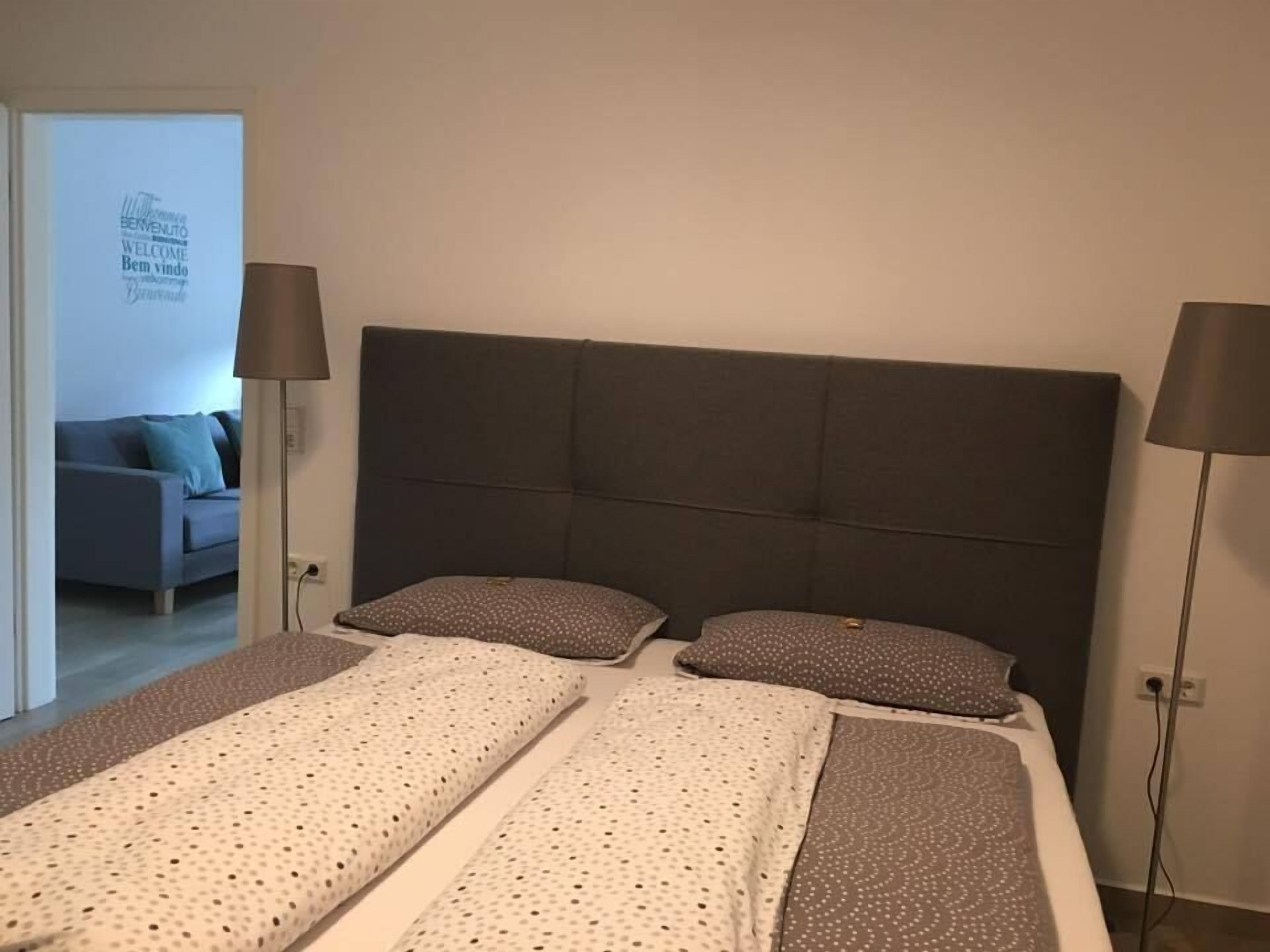 A bedroom with a large bed, two bedside tables, and a headboard.