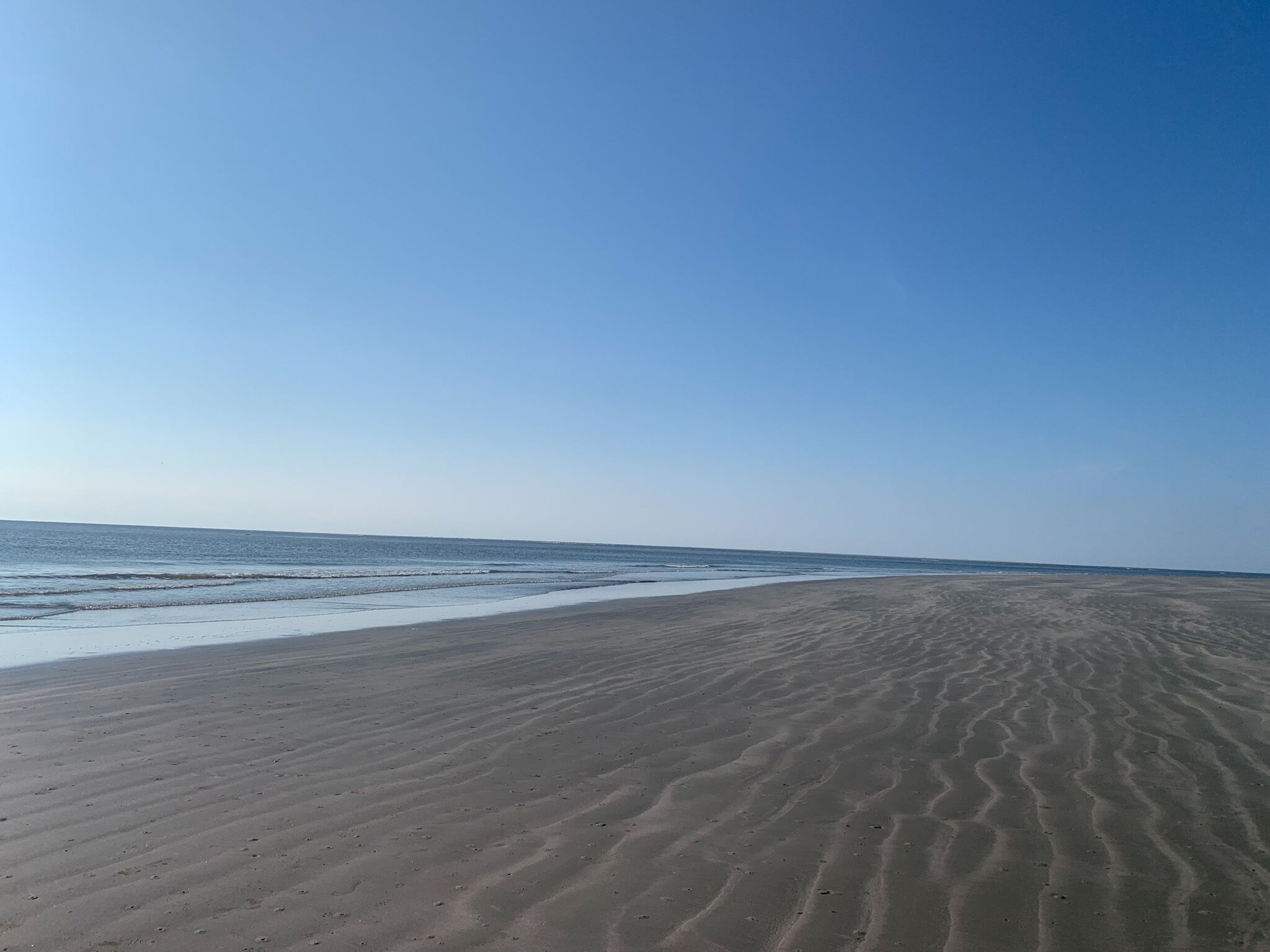 Une plage avec une vaste étendue de sable et des vagues douces.