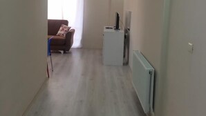 A spacious living area with a brown sofa and a white cabinet. - Otel Gerger (Gerger)