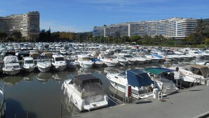 A marina with numerous boats docked, surrounded by multi-story buildings. - Apartment "Le Jean Bart" with pool and views of Cannes Marina (Mandelieu-la-Napoule)