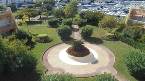 A landscaped area with a central circular garden, surrounded by well-maintained grass and trees. - Apartment "Le Jean Bart" with pool and views of Cannes Marina (Mandelieu-la-Napoule)