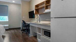 A modern kitchen with white cabinetry, a built-in oven, and a flat-screen TV mounted above the counter. - Extended Stay America Premier Suites Bluffton Hilton Head (Bluffton)