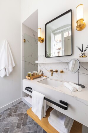A modern bathroom with a white marble sink, gold fixtures, and a large mirror. - Boutique Hotel Stari Grad (Dubrovnik)