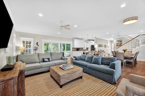 Ein geräumiges Wohnzimmer mit zwei Sofas, einem Couchtisch und einem Essbereich mit Tisch und Stühlen.